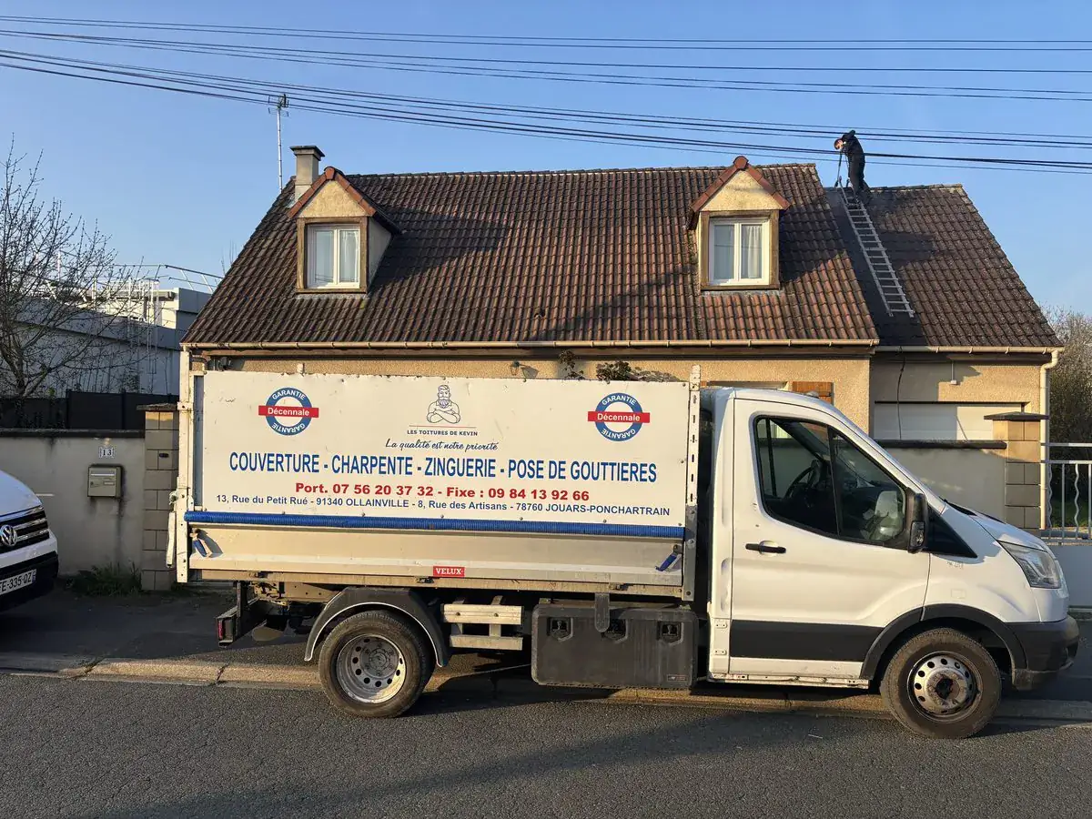 Les Toitures de Kevin, couvreur à Jouars-Pontchartrain — camion benne de l'entreprise devant un pavillon, couvreur au travail sur le toit
