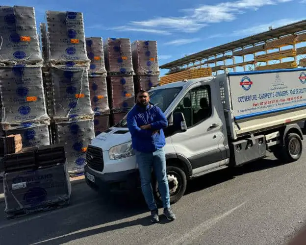 Les Toitures de Kevin, couvreur à Auffargis — Kevin Paumard devant le camion benne de l'entreprise, chargé de matériaux