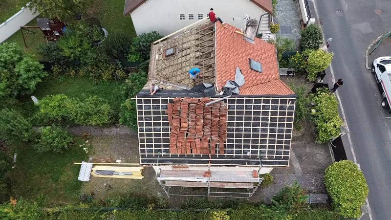rénovation de toiture dans les Yvelines — vue aérienne d'une toiture en cours de rénovation, tuiles déposées et écran sous-toiture posé